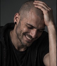 Pulse smiling, hand resting on top of his head.