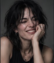 Vanta laughing, resting her chin on her hand.