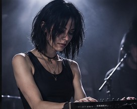 Vanta playing a synthesizer on stage, head down in concentration.