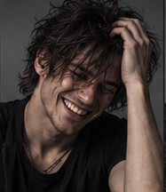 Wire smiling, running a hand through his hair.